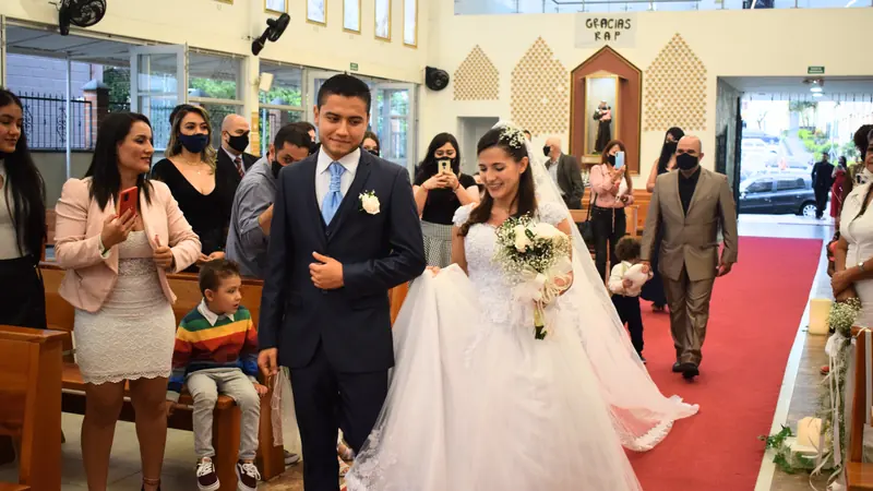 Una pareja camina hacia el altar el día de su boda