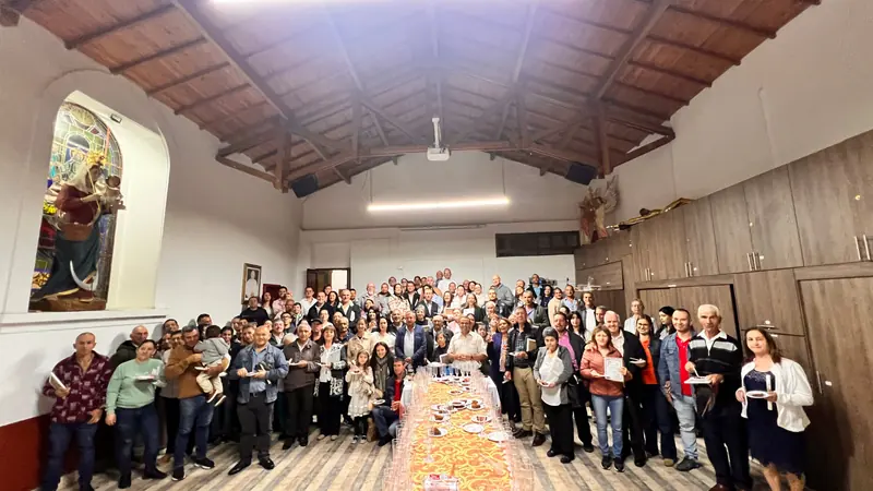 Matrimonios y familias reunidos en un salón parroquial